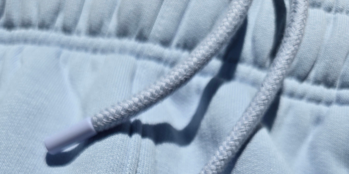 Closeup image of drawcord on light blue sweatpants.