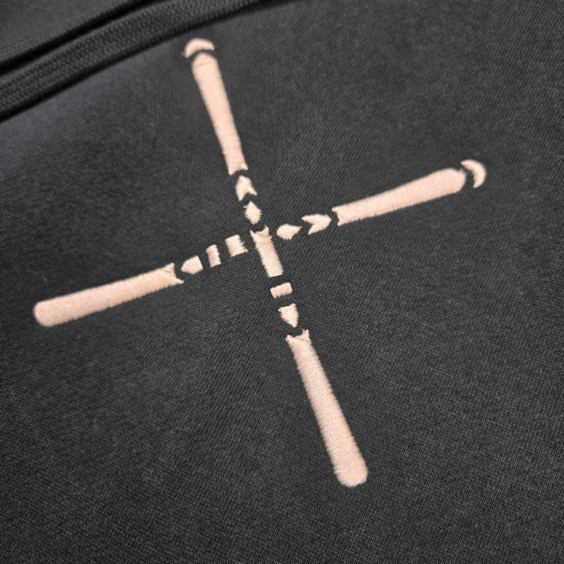 closeup of swith apres alpine club fleece hoodie in dark green with embroidered logo of crossed skis in off-white color