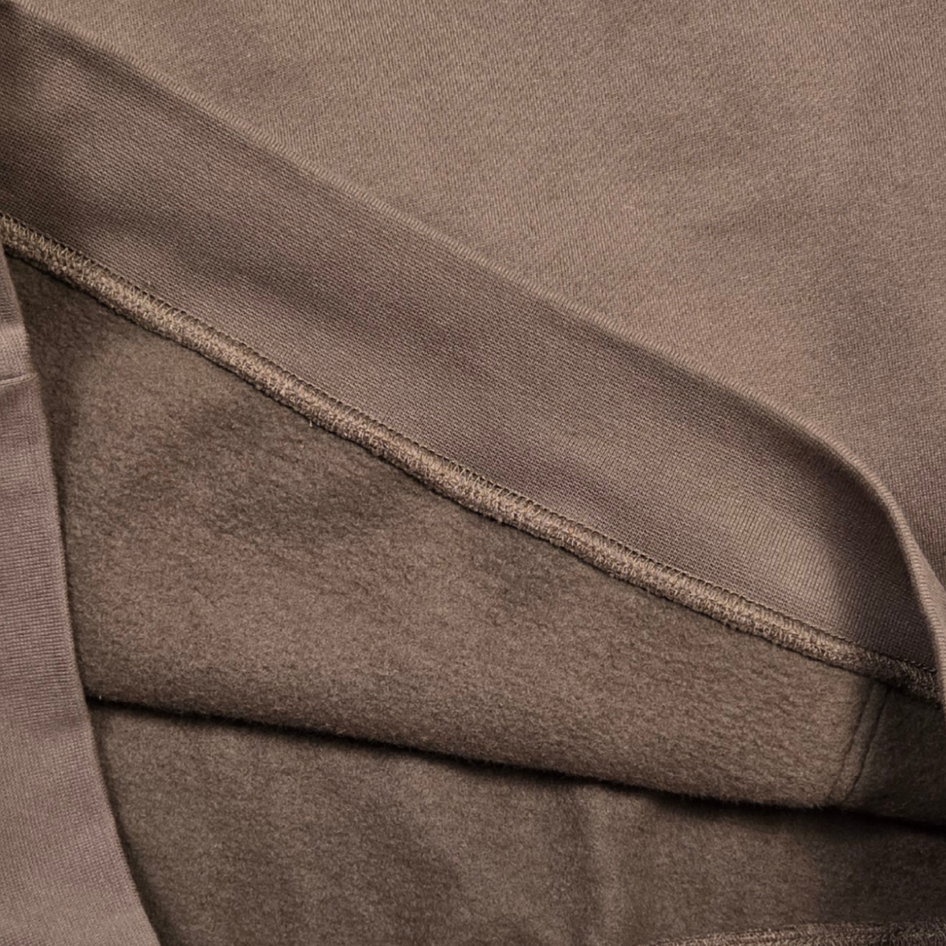 Close-up of swith backcountry ski club fleece hoodie inside of brown brushed fleece fabric with a visible seam