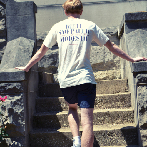 Athlete wearing apres run club crewneck tee with text on the back, walking up stone steps and wearing swith riviera collection shorts.
