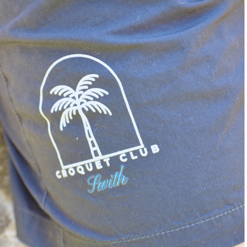 Logo of swith croquet club with palm trees on a blue background