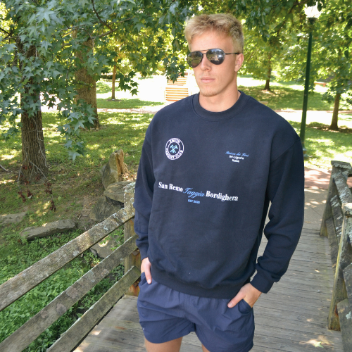 Athletic man wearing swith croquet club relaxed crewneck in the color navy in a park setting